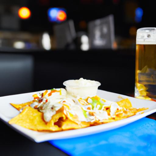 Đĩa nachos và một ly bia trên bàn tại quán bar thể thao